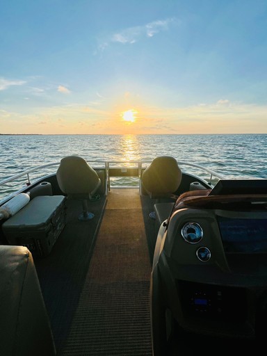 Pontoon boat onboard looking aft into a sunset