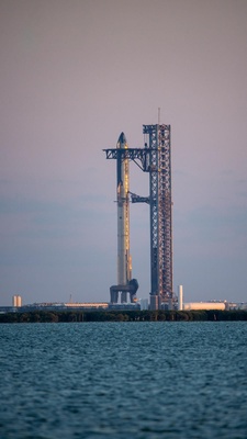 Close-up photo of the SpaceX Starship rocket fully stacked on the pad from a Star Fleet boat nearby in the South Bay passage.